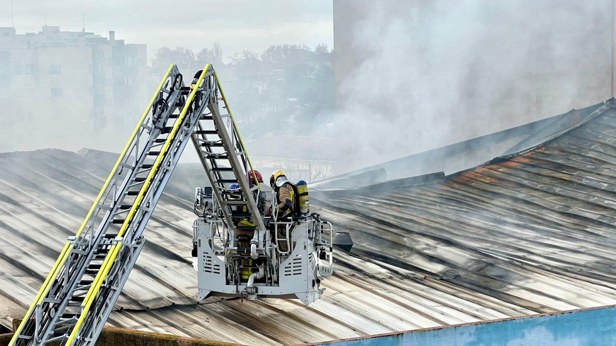 Imagen de los Bomberos actuando este pasado domingo sobre la cubierta de la nave afectada por el incendio en Reus.
