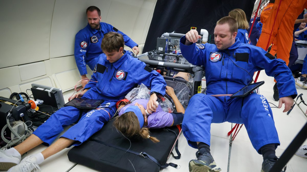 Huc, a la izquierda, atado por las piernas durante un vuelo parabólico para evitar flotar y poder realizar las pruebas correspondientes al astronauta.