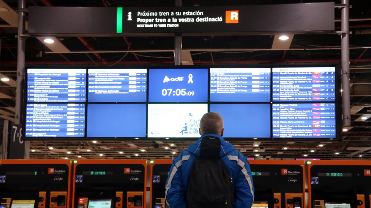 Una persona observa los paneles informativos en una estación.