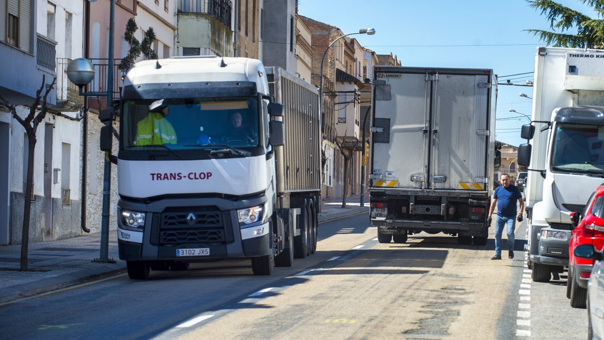 Camions passant per la carretera, que té el ferm en mal estat, aquest dimarts.