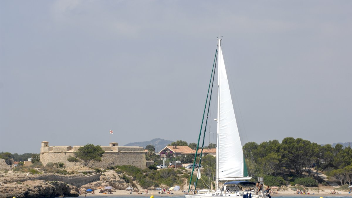 Un veler navegant per la costa de l'Ametlla de Mar.