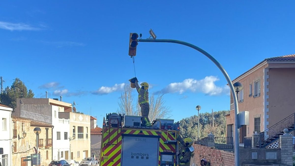 Un bombero extrae una parte de un semáforo de la C-44 que está a punto de caer.