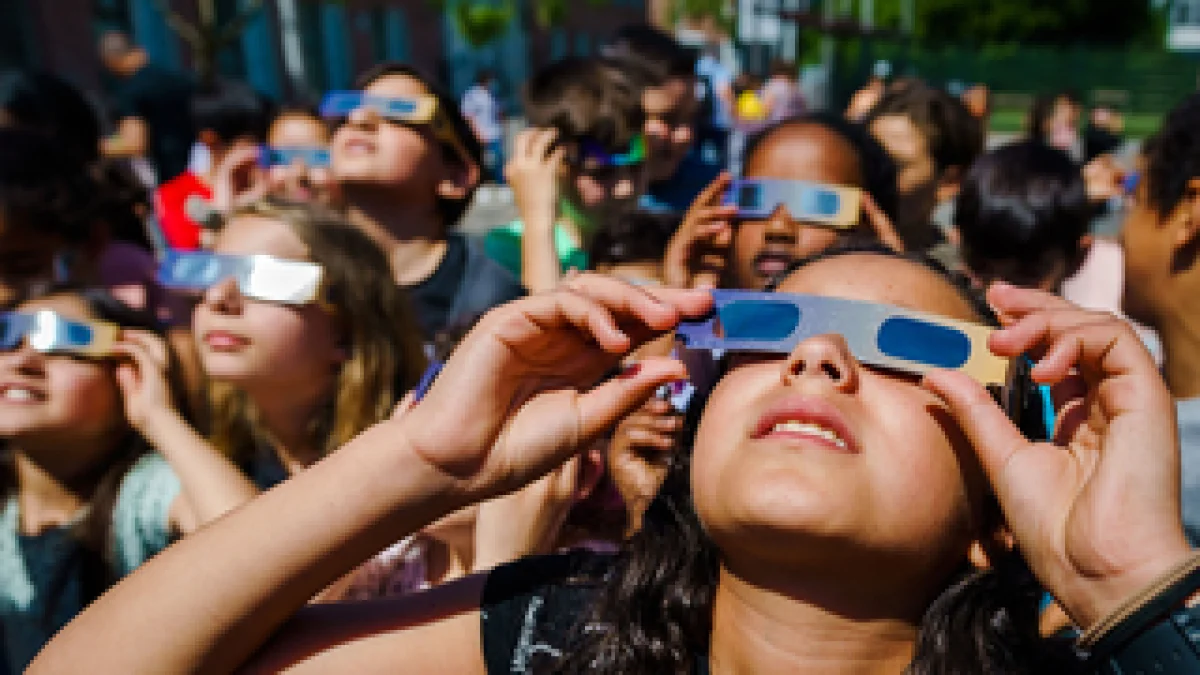 Jóvenes con gafas especiales para seguir un eclipse.