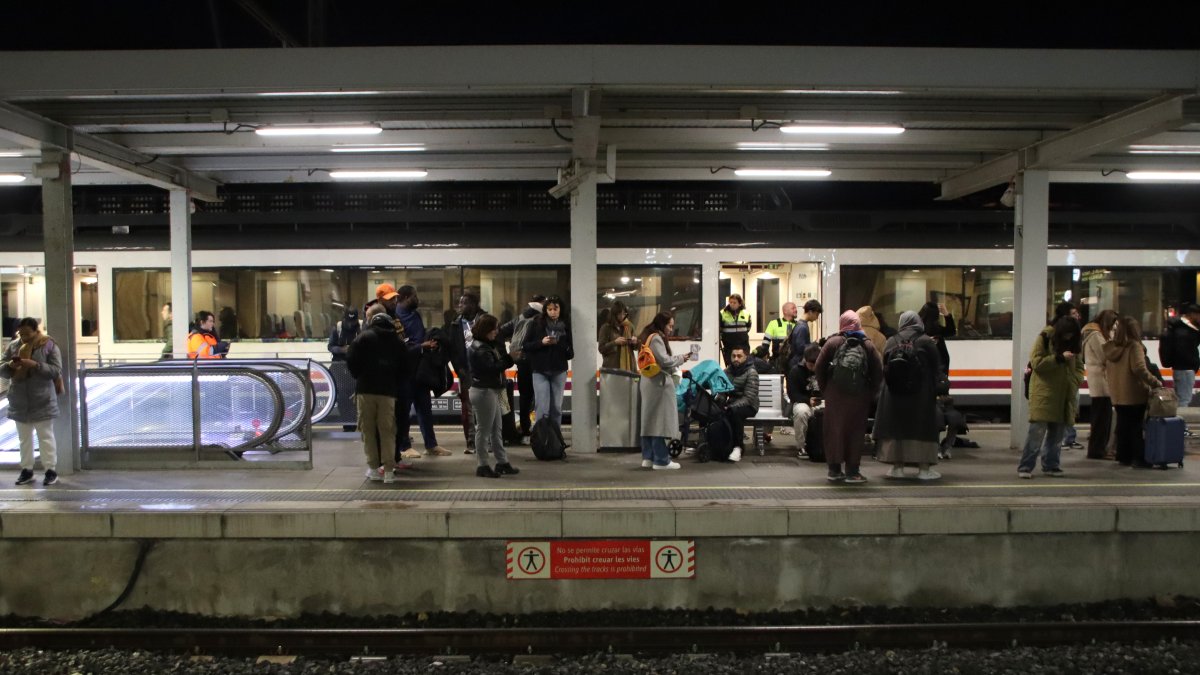 Usuarios en el andén de la estación de Tarragona esperando un tren que llega con retraso
