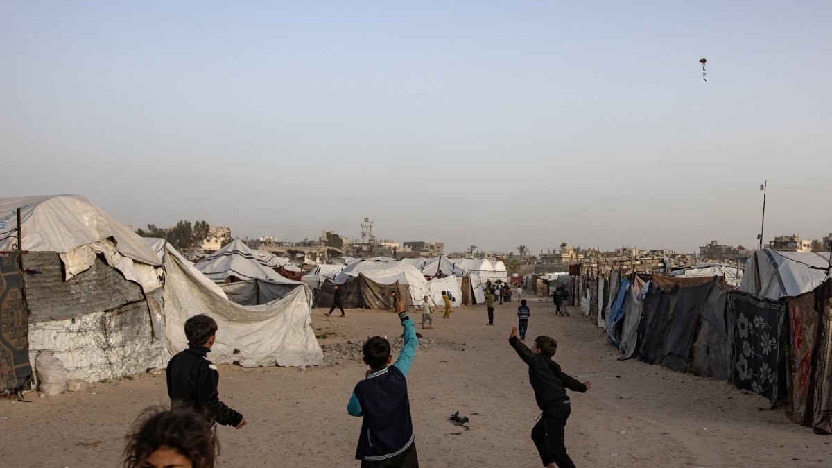 Niños desplazados juegan cerca de un campamento temporal de tiendas en Jan Yunis, en el sur de la Franja de Gaza