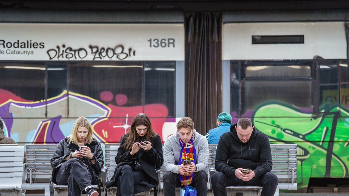 Usuarios esperan que pase un tren en Barcelona, durante el primer día de huelga de maquinistas