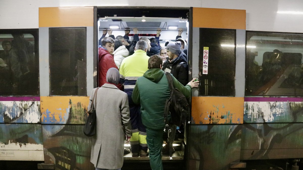 Un tren sin espacio y con pasajeros sin poder entrar debido a la reducción de frecuencias provocada por la huelga del sector.