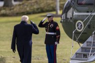 El presidente de Estados Unidos, Donald Trump (espaldas) saluda a un soldado antes de subir al helicóptero presidencial.