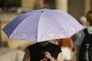 Una turista se protege del sol con un paraguas. El puente de agosto comienza con España inmersa en una larga ola de calor
