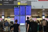 Pasajeros consultando las pantallas de información de vuelos en la terminal 2 del aeropuerto de El Prat.
