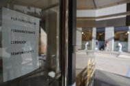Cartel que indica el cierre temporal en la fachada principal de la clínica dental de Alzira.
