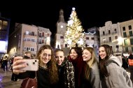 Un grup d'amigues es fa una fotografia amb l'arbre de Nadal, just després de l'encesa.