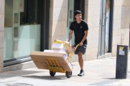 Un repartidor transporta paquetes en uno de los picos de más calor en el Puente de Piedra de Girona