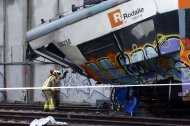Varios bomberos trabajan en la zona cero del accidente de tren ocurrido el martes en Gelida (Barcelona).