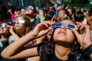 Jóvenes con gafas especiales para seguir un eclipse.