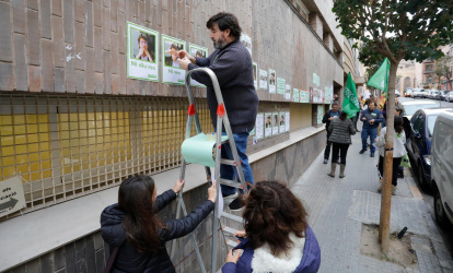 Representantes educativos pegando carteles en la fachada de los Serveis Territorials de Educació de Tarragona.