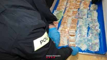 Un mossso durante el recuento del dinero intervenido.