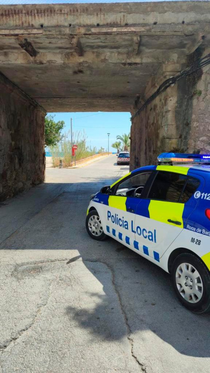Un coche de la Policía Local de Roda de Berà y, de fondo, uno de los Mossos d’Esquadra, en el lugar donde ha aparecido el paquete.