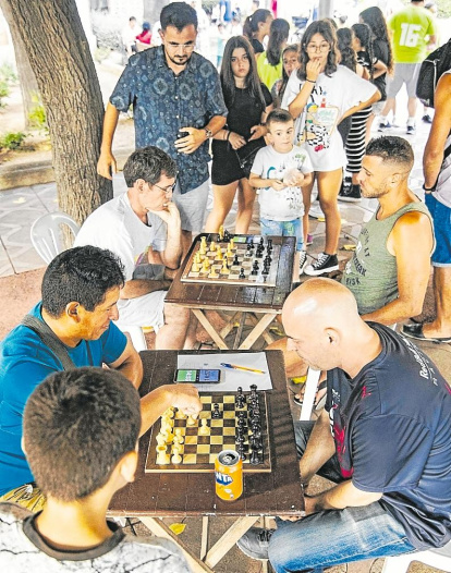 Vecinos disputando un torneo de ajedrez en las fiestas de Parc Riu Clar.