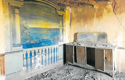 El fresco de la casa, en el que se ve un atardecer en una playa, ahora muy deteriorado.