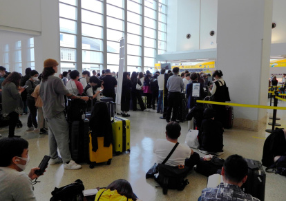 Viajeros esperando en el aeropuerto de Naha tras la alerta de tsunami en Japón.