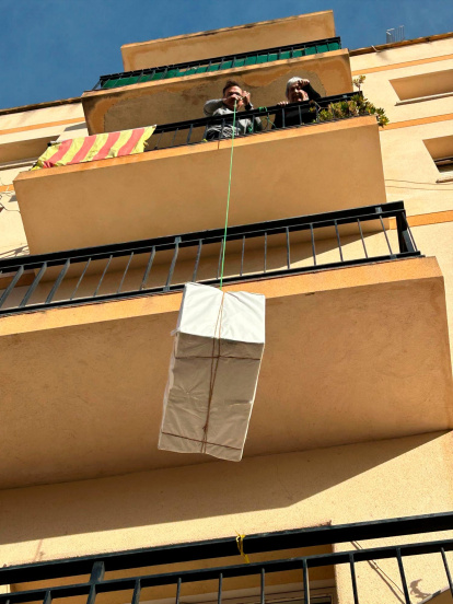 Atar los regalos a una cuerda y subirlos por el balcón, toda una tradición en Cambrils.